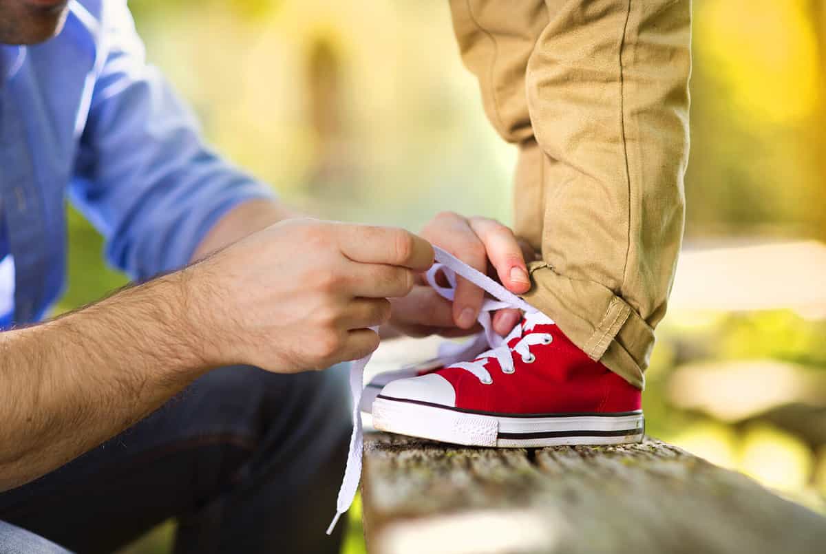 In his shoes. Завязывать шнурки. Дети в кроссовках. Ребенок завязывает шнурки. Человек в кроссовках.