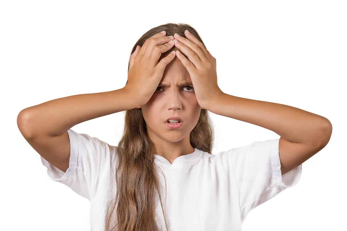 Stress, trouble, headache. Portrait stressed teenager girl hands on head overwhelmed in life school isolated white background. Negative human facial expression emotion feeling perception body language