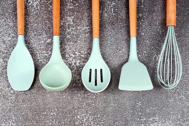 Kitchen utensils, home kitchen tools, mint rubber accessories on dark background. Restaurant, cooking, culinary, kitchen theme. Silicone spatulas and brushes, free copyspace for text