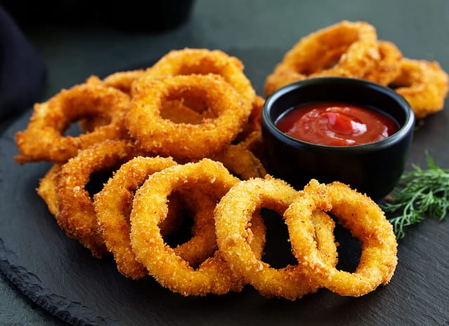 Homemade crunchy fried onion rings with tomato sauce