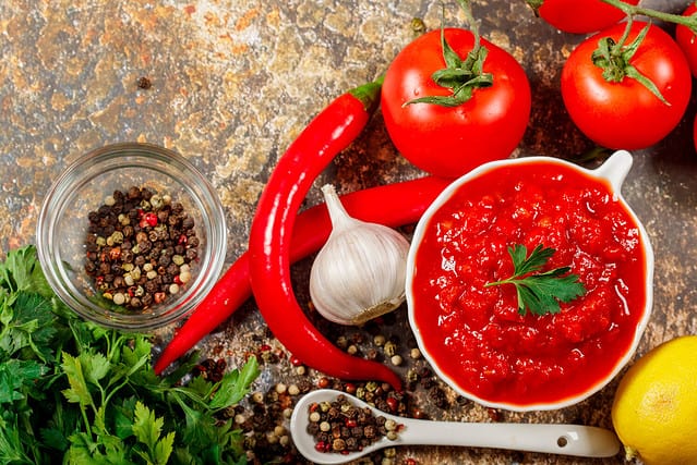 Salsa Sauce. Spicy, colorful Mexican salsa sauce with hot peppers and tomatoes on a dark background.Classic homemade Italian tomato sauce for pasta pizza in on wooden background.