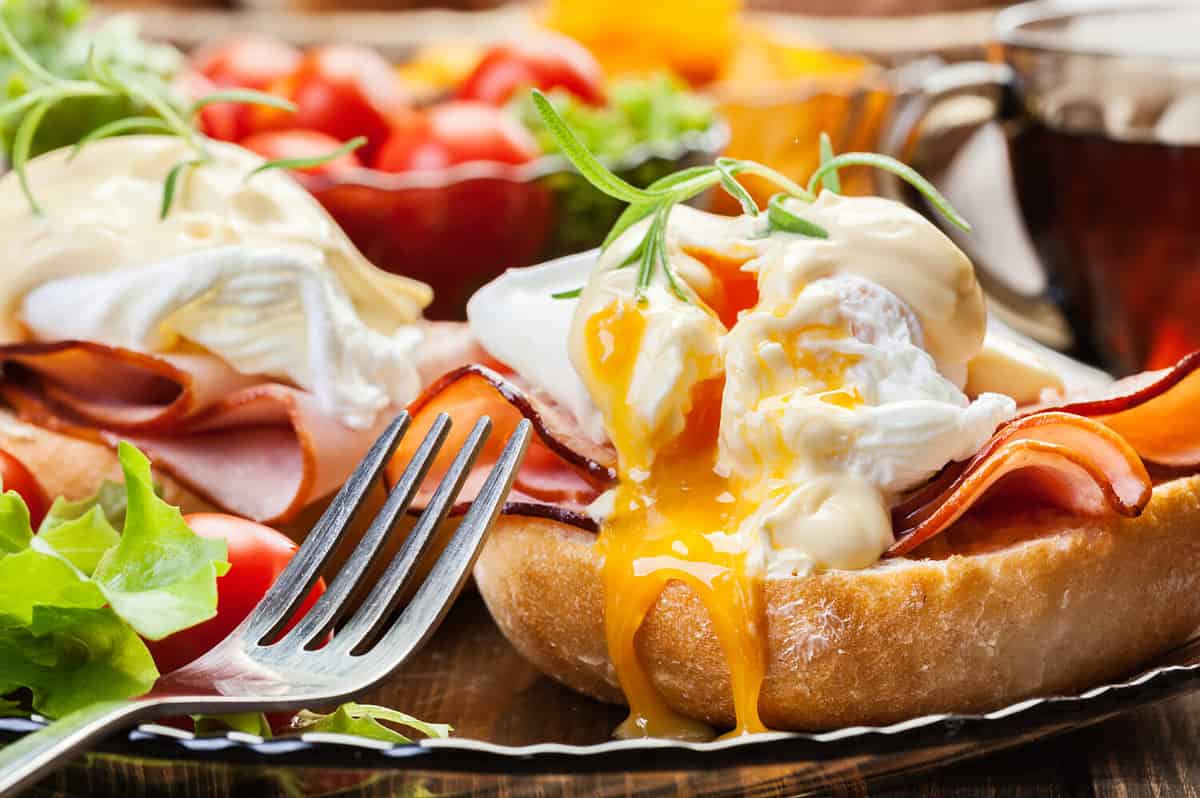 Eggs Benedict on toasted muffins with ham and sauce