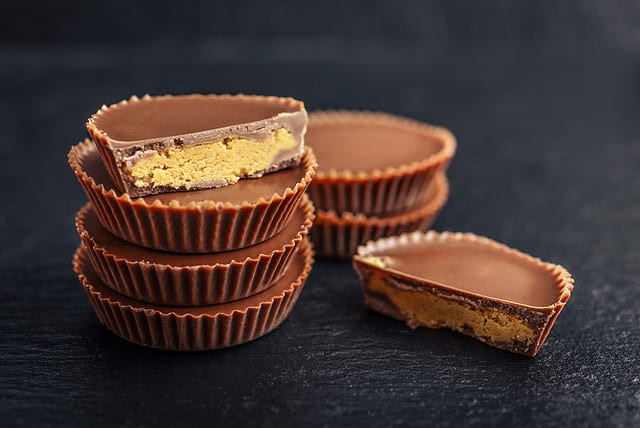 Peanut butter cups, chocolate dessert on black background closeup