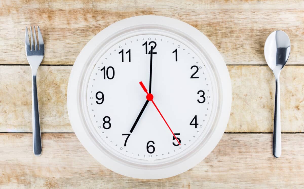 spoon,fork,clock over the wood desk from top view/ Breakfast in the morning