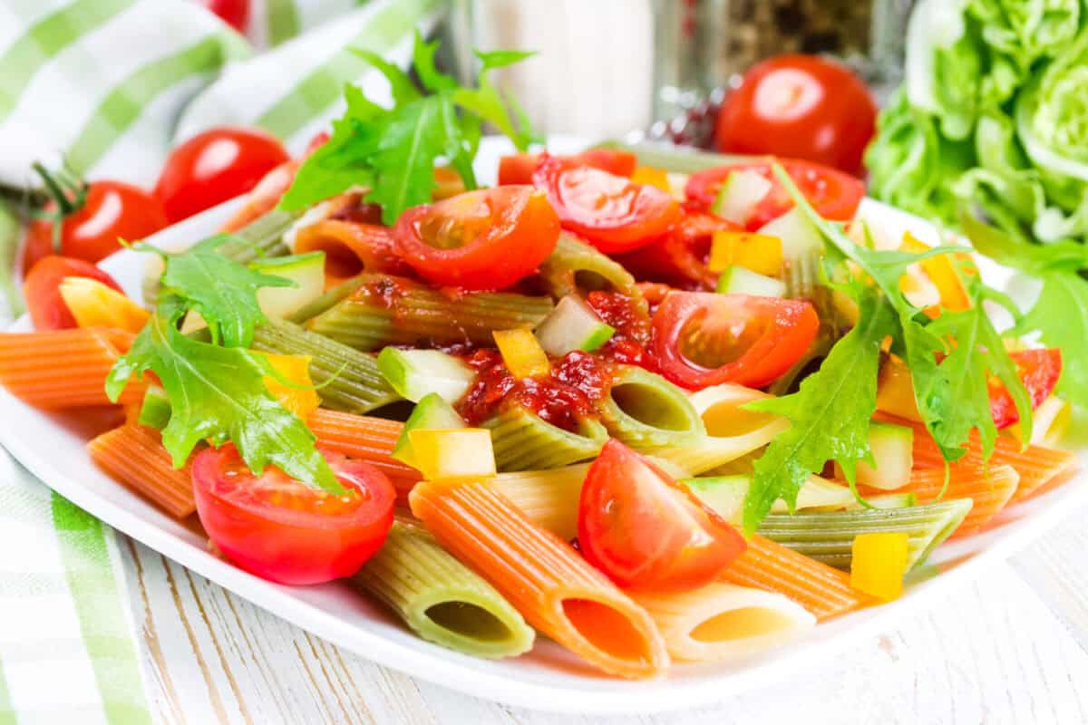 Colorful pasta on a white plate on a wooden