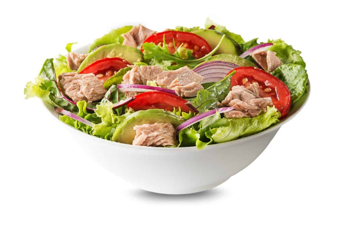 Fresh green leafy salad with tuna avocado and tomato isolated on white background. Concept for a tasty and healthy meal