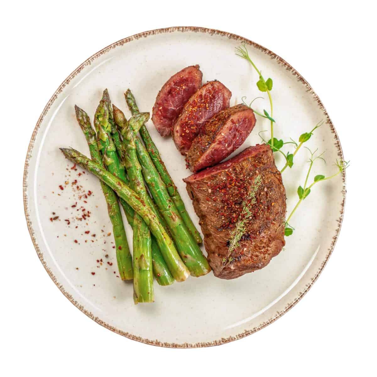 grilled beef steak with green asparagus isolated on white background, Roast beef with vegetables.
