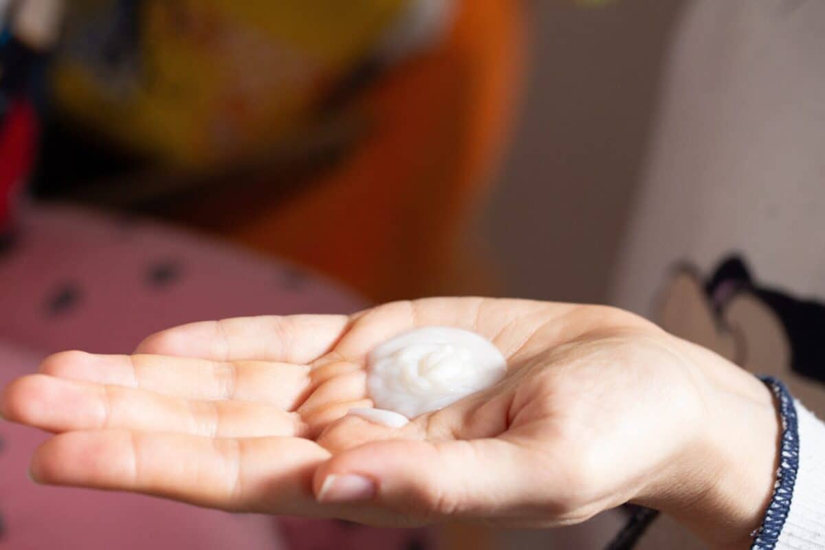 Palm of a hand presenting a swirl of rich moisturizing cream, ready for application to nourish the skin