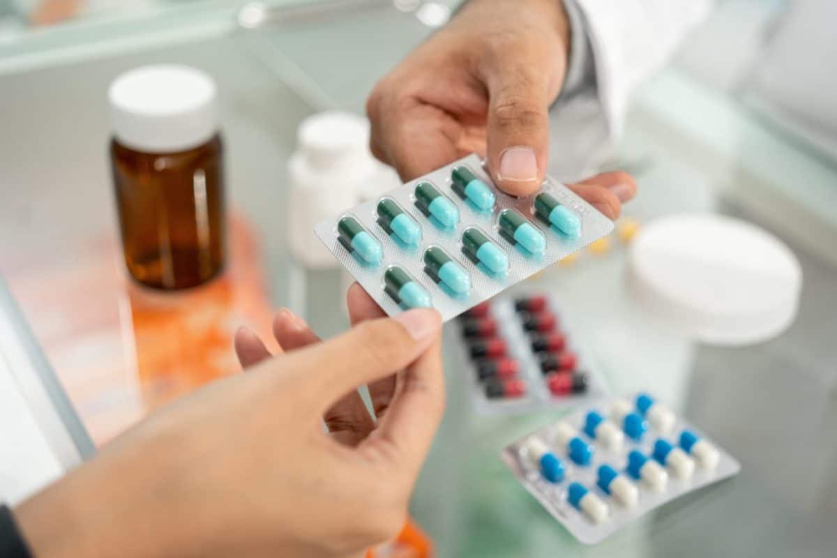 Pharmacist recommends medicines to customers. Asking the questions of medication. Professional Asian male pharmacist giving prescription medications to female patient customers at drugstore shelves. Things you should never put down the kitchen drain