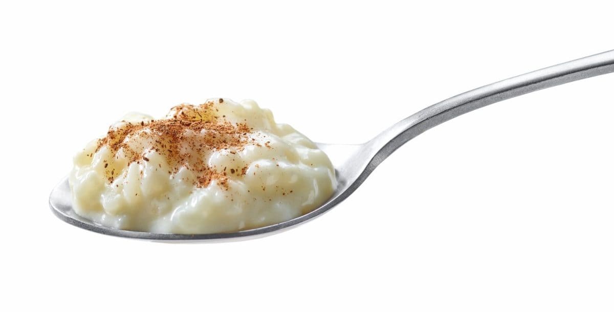 spoon of rice milk pudding with cinnamon isolated on white background.  healthy breakfast ideas for busy mornings