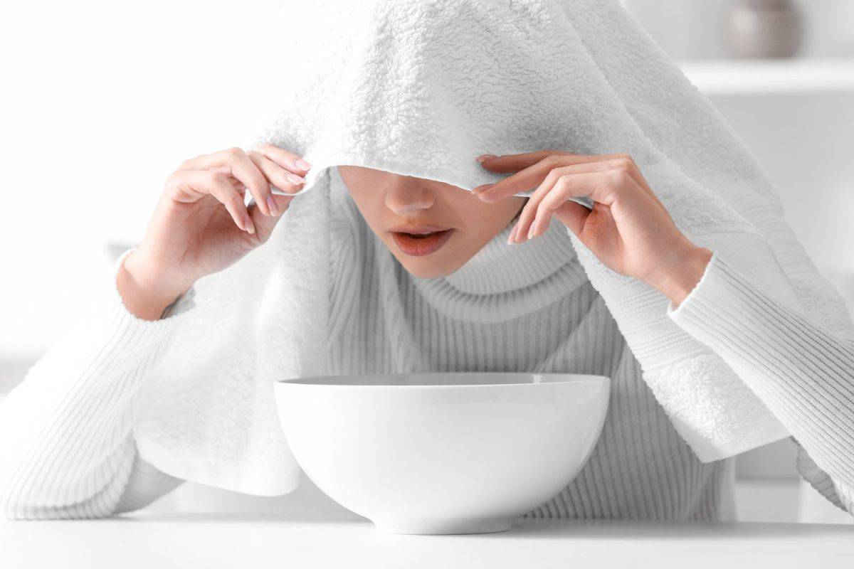 Young woman doing steam inhalation at home to soothe and open nasal passages. The best treatment options for croup.