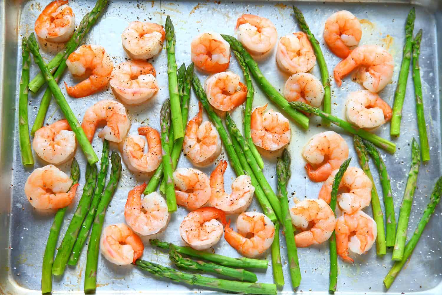 Sheet pan dinner of shrimp and asparagus with olive oil and black pepper