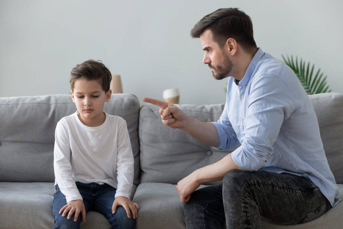 Angry mad father scolding lecturing sad preschool kid son for bad behavior at home, serious parent dad punish little upset guilty child boy pointing finger demand discipline, family conflicts concept