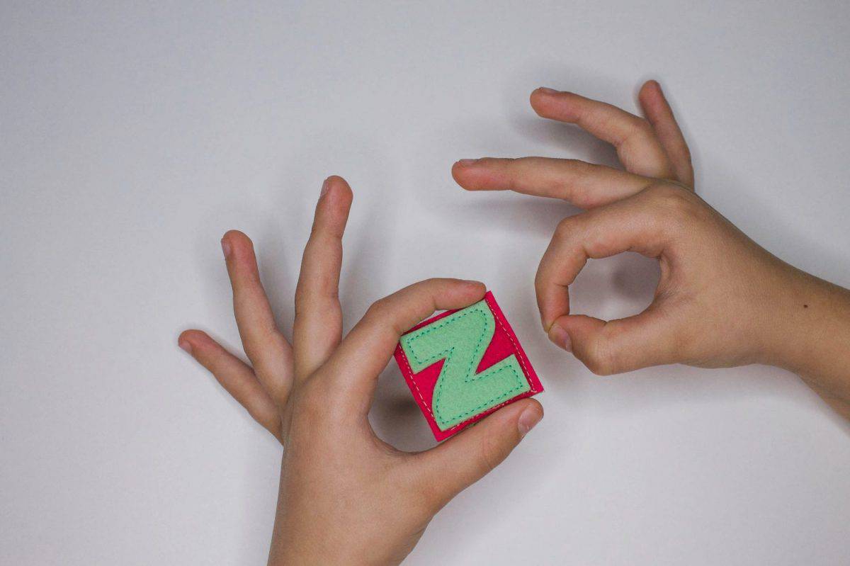 Alphabet. Letter Z. Hands of the child hold letters. Learn ABC alphabet with baby.