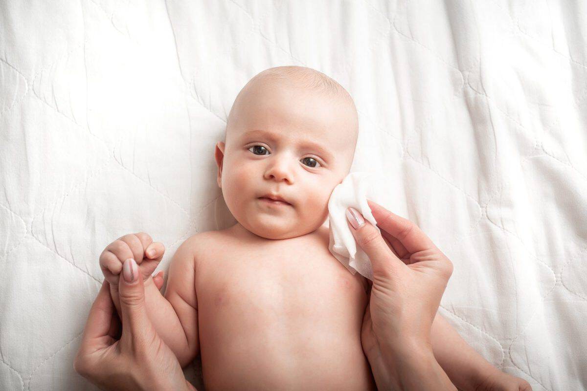 Mother Wiping Baby's Face. Concept Hygiene cleaning wipe, pure, clean.