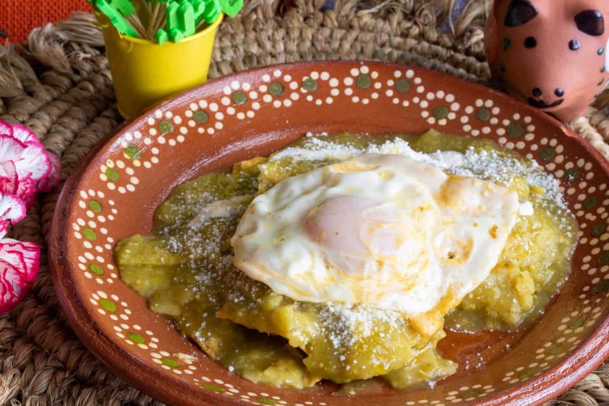 Mexican food Green chilaquiles with over medium eggs, with sour cream and cheese