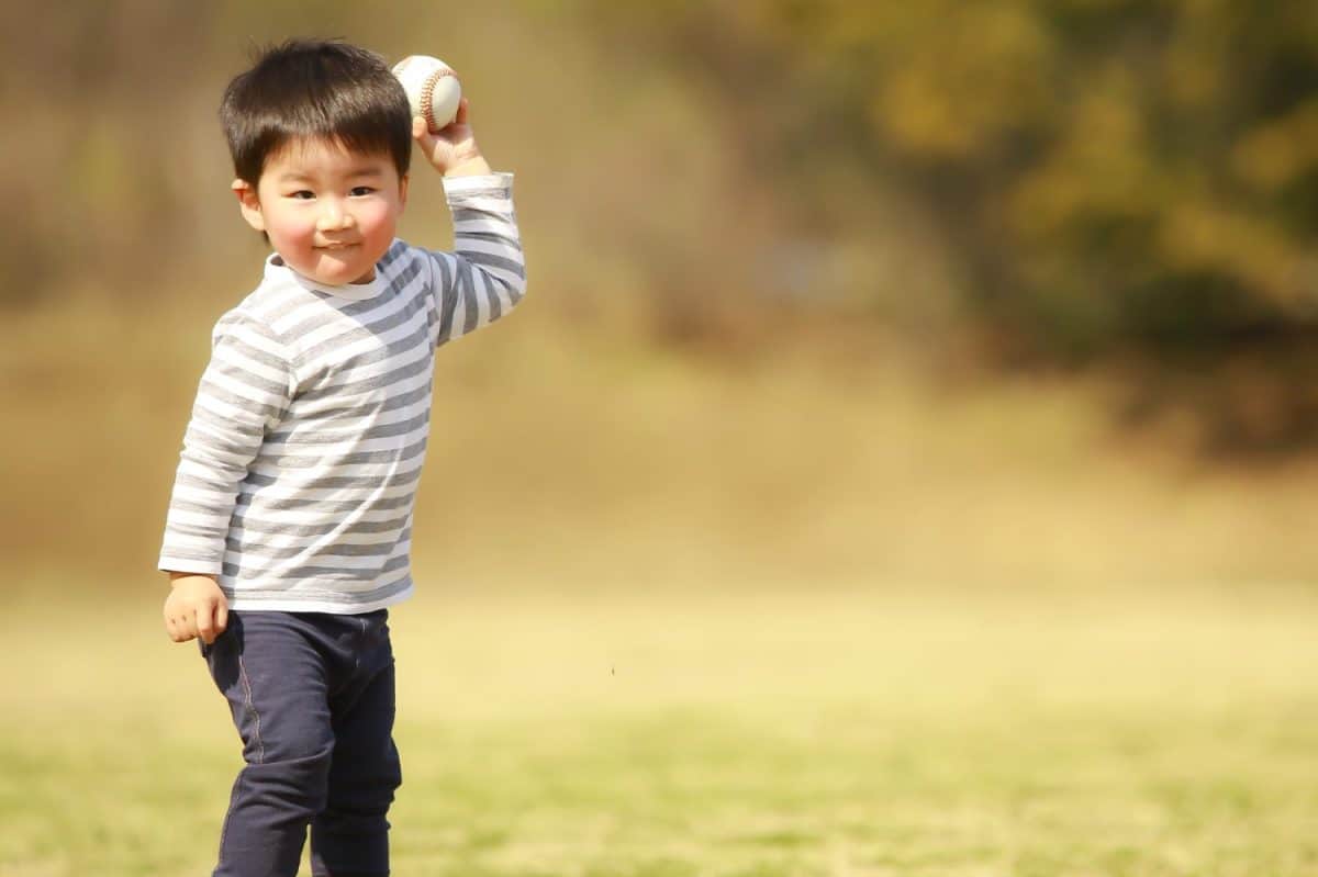 Boy playing with a baseball ball