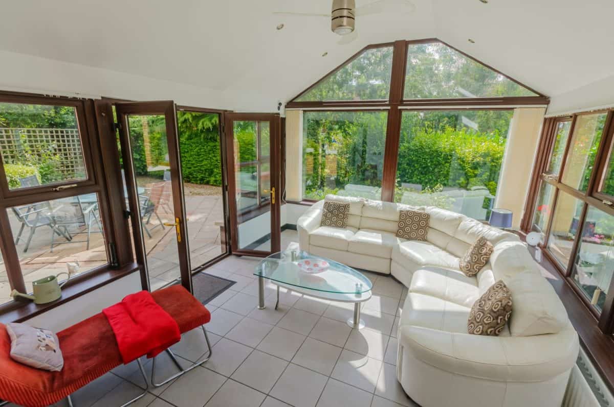 Sunroom in a modern bungalow with a white leather sofa