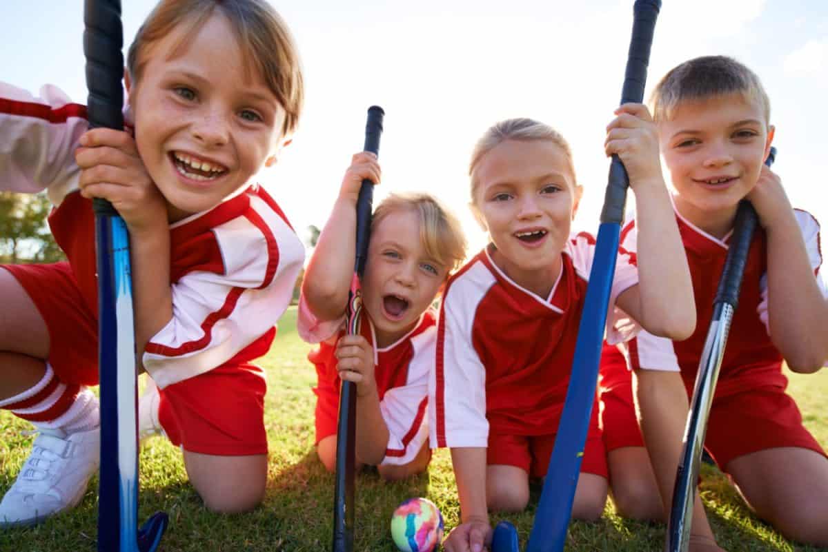 Theyve got strong team spirit. Portrait of happy children playing field hockey.