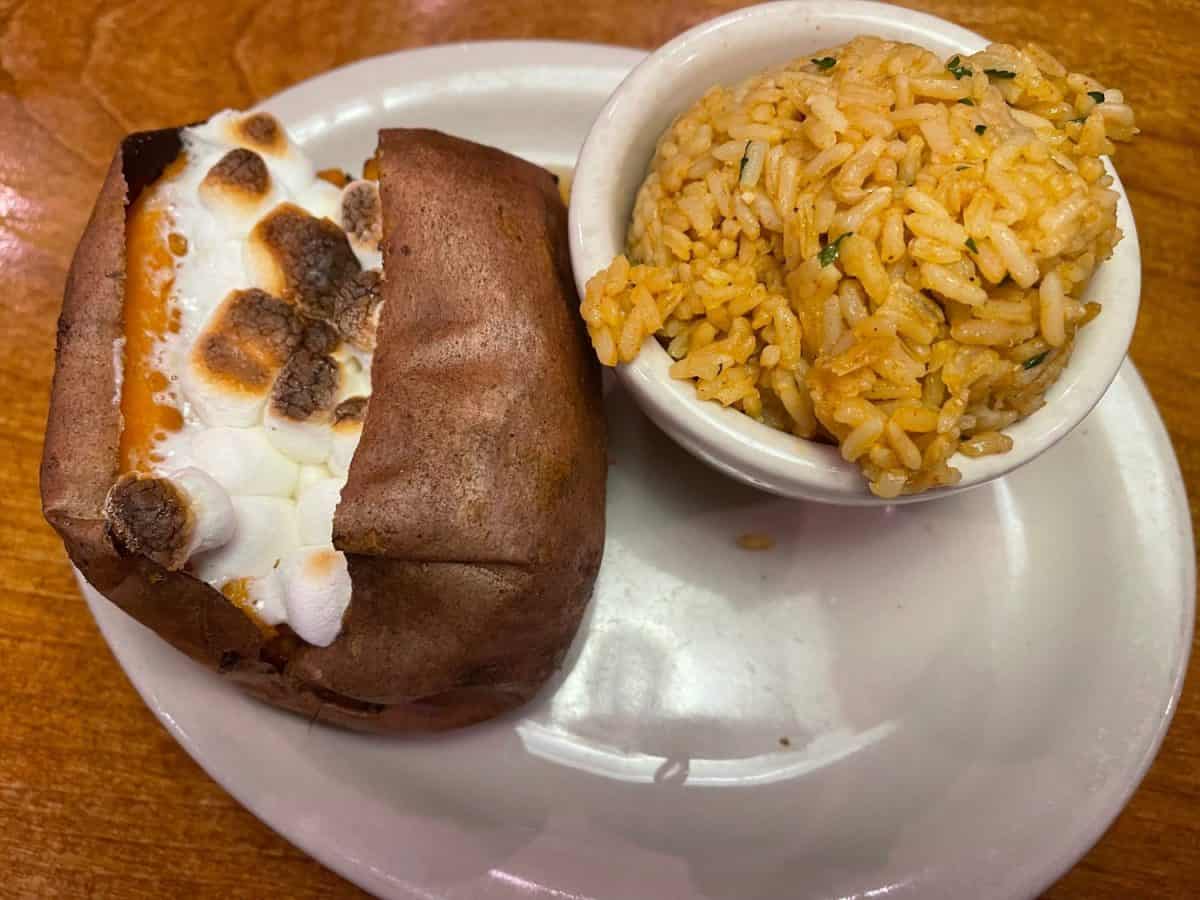 Loaded sweet potato with cinnamon sugar and marshmallows. Seasoned rice. Texas Roadhouse.