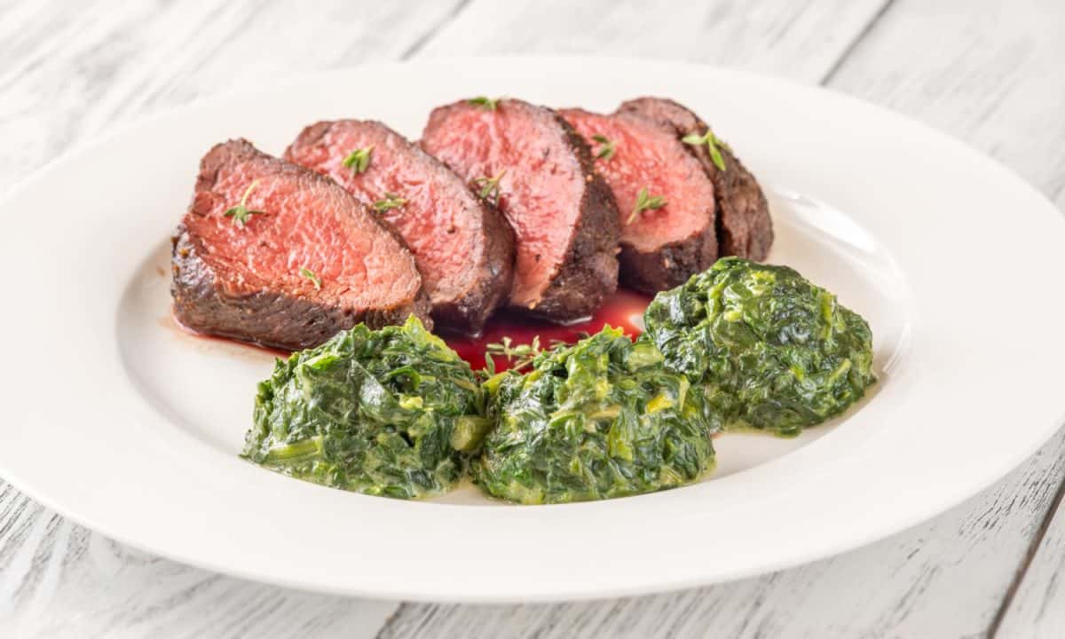 Flank steak with creamy spinach on the plate