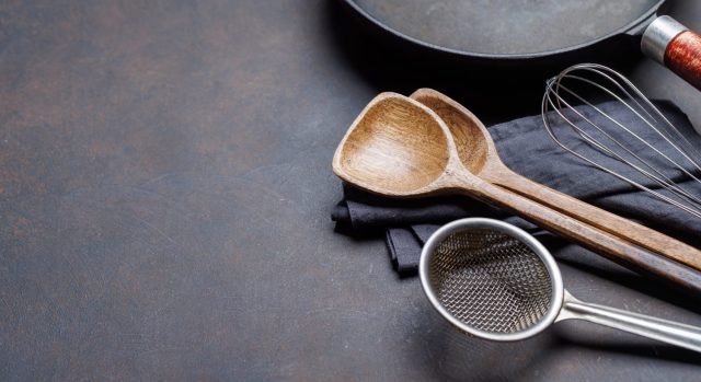 Culinary essentials: Diverse cooking utensils on stone table. With copy space