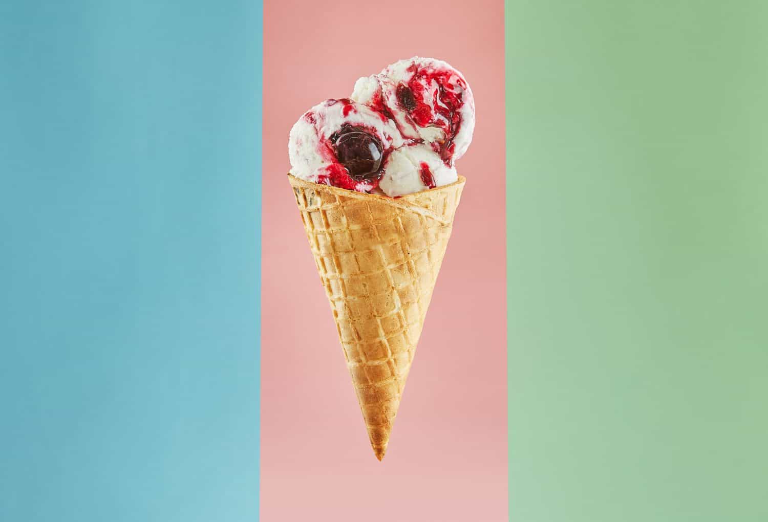 A closeup view of a single ice cream cone with two scoops of strawberry and vanilla ice cream, topped with a decadent drizzle of rich chocolate sauce. Isolated on a pastel pink background.