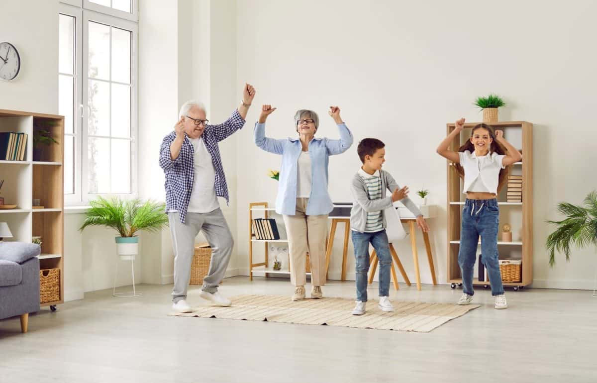 Different generations have good time together. Funny senior couple at home having fun and dancing with their grandchildren. Brother and sister dancing in living room together with with grandparents. 10 Fun and creative ways celebrate grandparents day