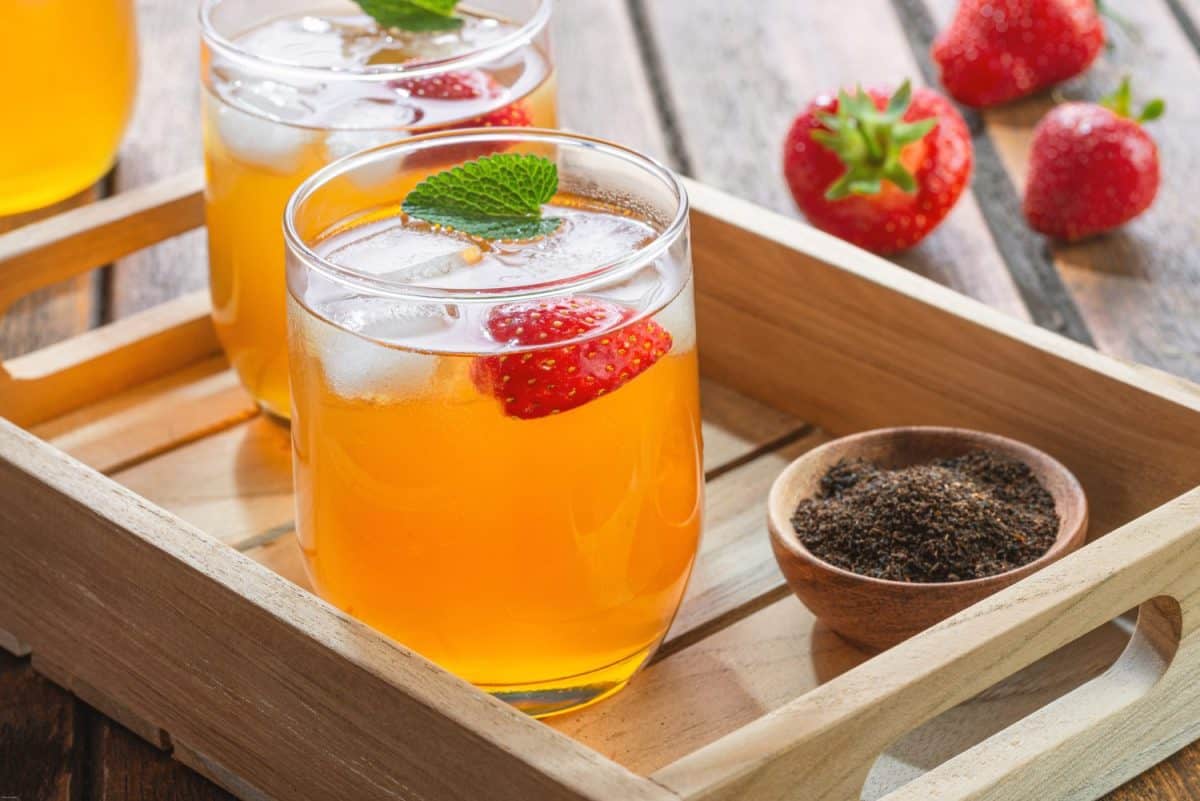 Fermented natural organic Kombucha with strawberries as a refreshing summer drink with ice cubes