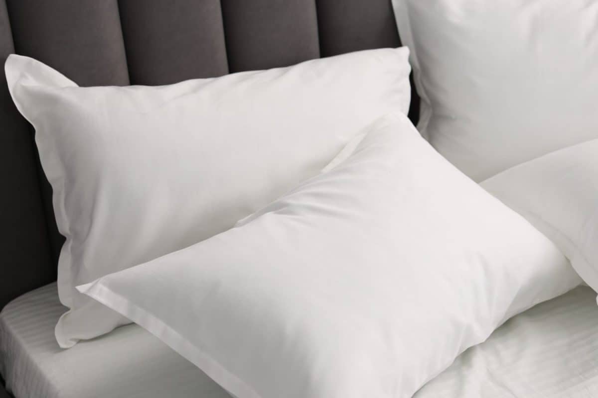 Many soft pillows on bed at home, closeup