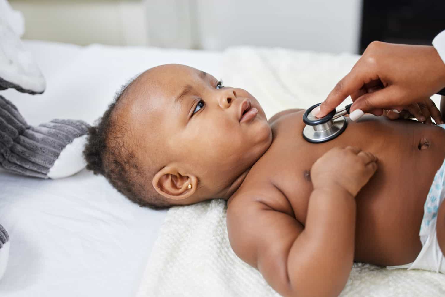 Doctor, black baby and stethoscope to listen in clinic, sick patient and monitor pulse for healthcare. Pediatrician, child and tool to check for heartbeat or exam on lungs, girl and infant for test