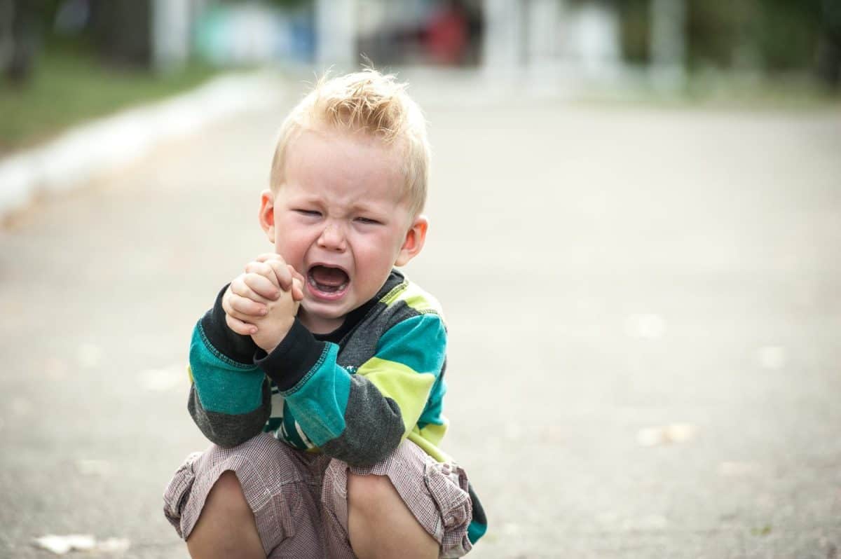 sad and unhappy child. Upset toddler boy. problem child with head in hands. concept for bullying, depression stress or frustration. Space for text. Stressed child. boy shouting. Cute boy shouts