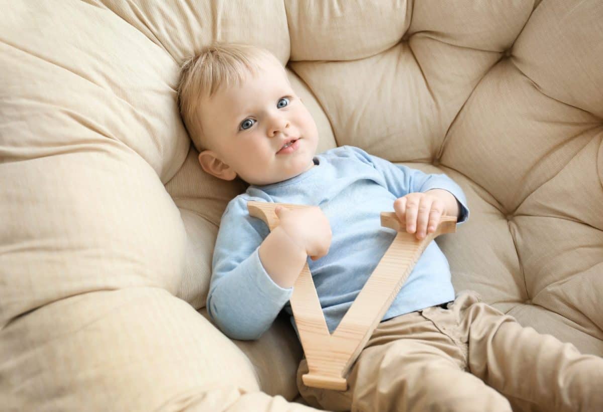 Cute little boy with letter V in armchair