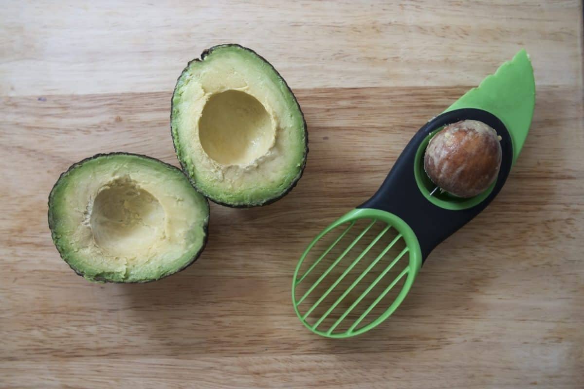 Avocado cut in half and pitted with three in one avocado preparation tool.