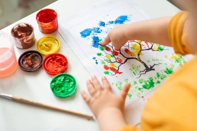 child painting with primary colors