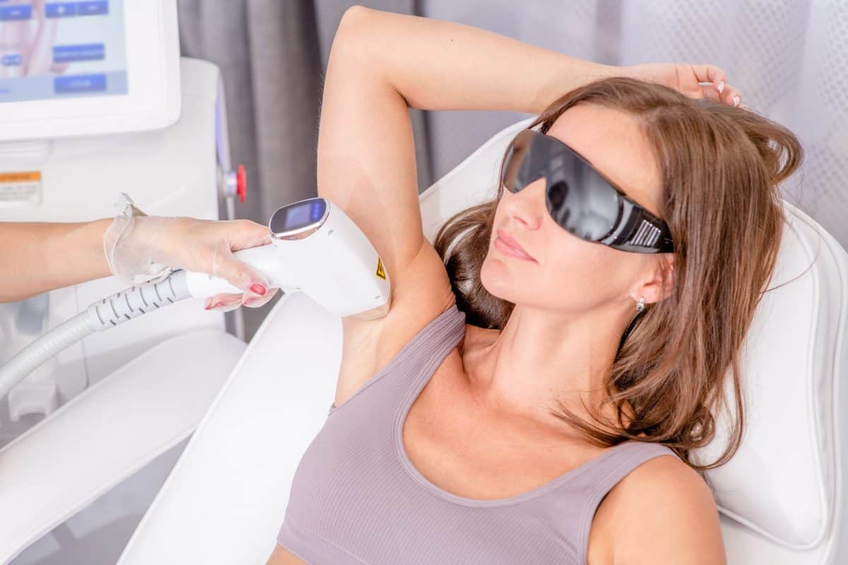 Professional beautician removes hair on armpit using a laser. Armpit hair removal with laser, procedure at clinic