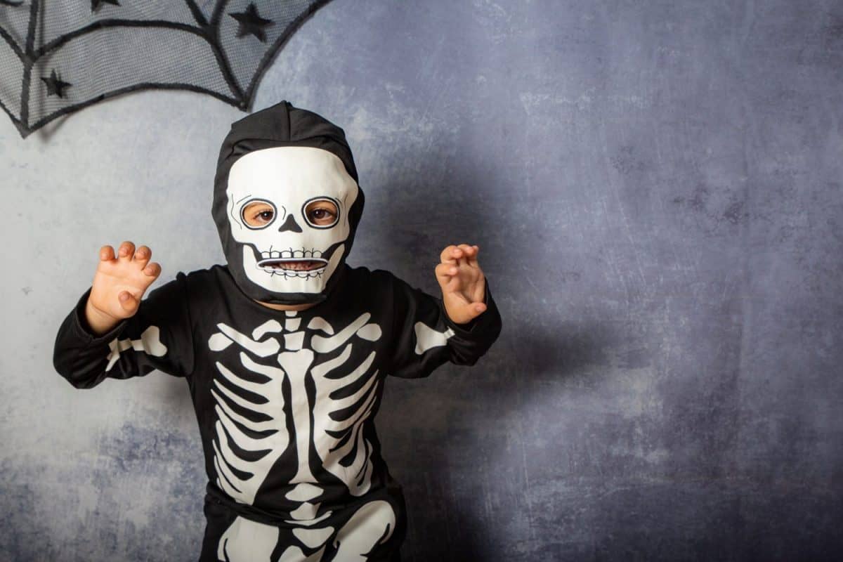 Little kid in a skeleton costume on Halloween Carnival