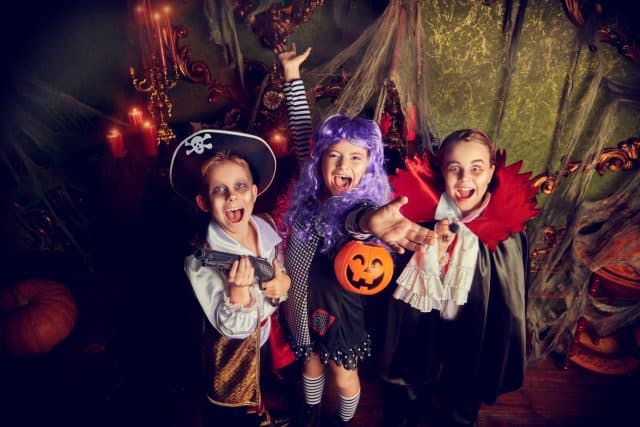 Happy children celebrate Halloween on a party with old castle decorations. Halloween.