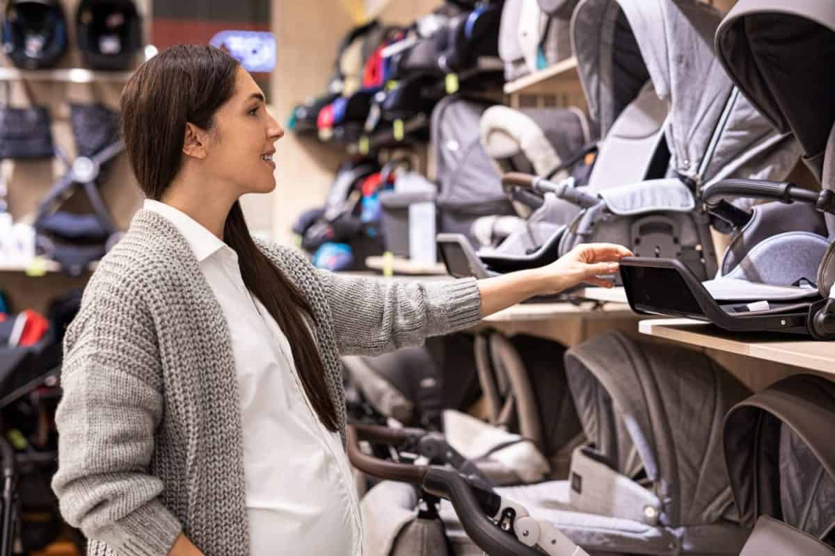 Beautiful pregnant woman in the baby equipment store