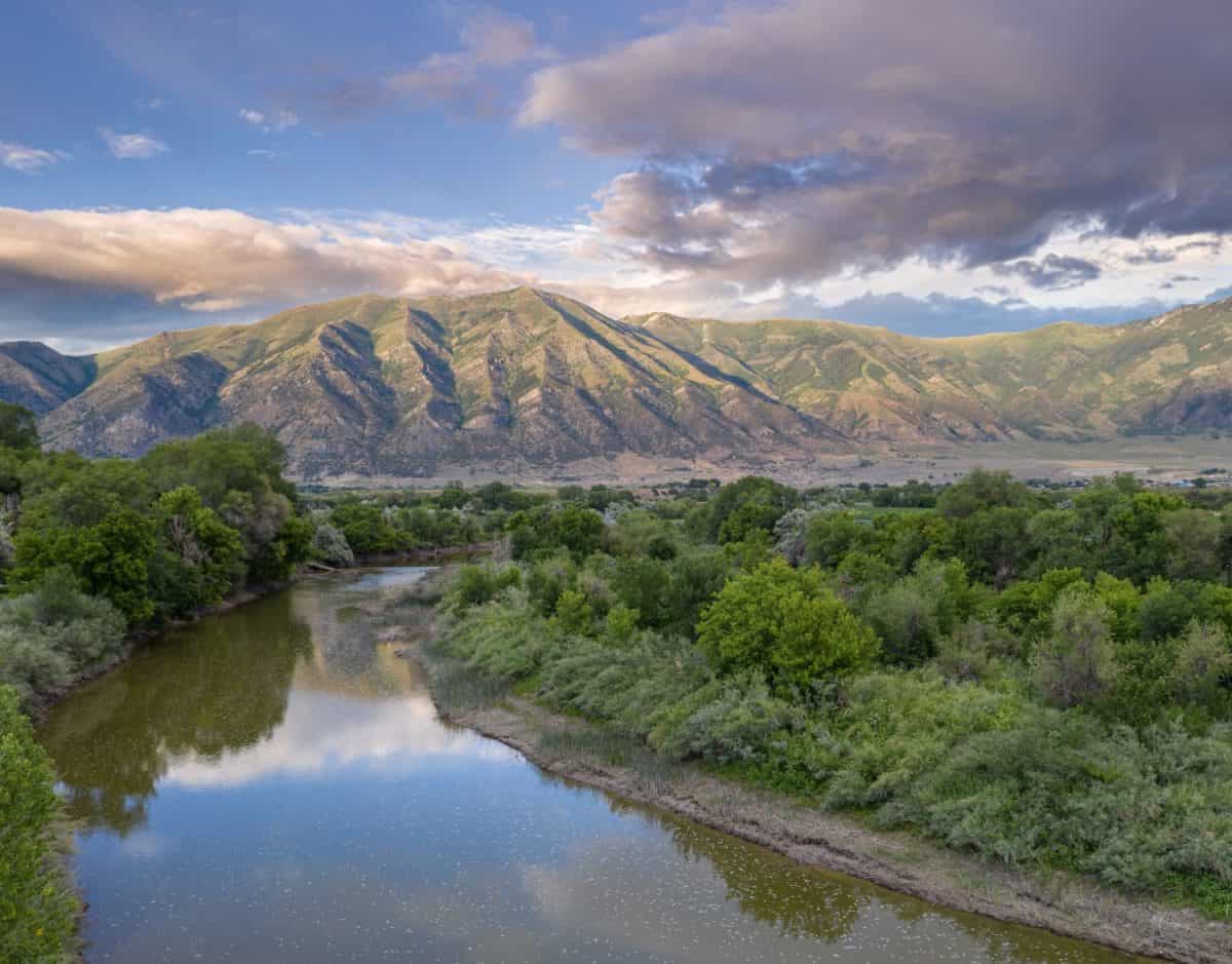 Beautiful Golden Hour Aerial Drone view of the Bear River and Wasatch Mountain Range near Elwood in Box Elder County, Northern Utah, no people