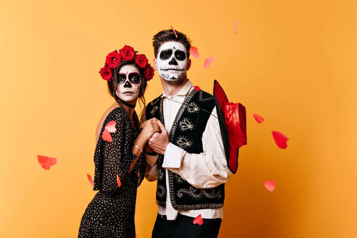 Charming, lovers man and woman make funny faces for portrait. Couple in traditional mexican costumes posing in studio