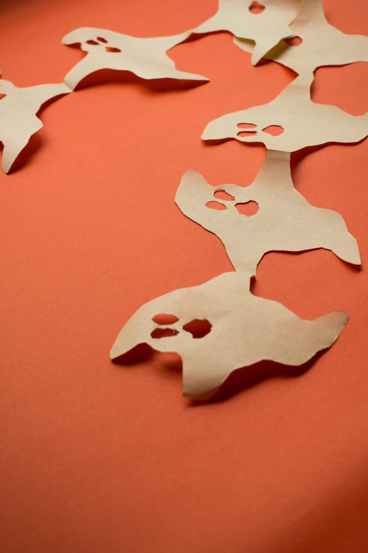 A vertical closeup shot of paper ghost halloween decorations