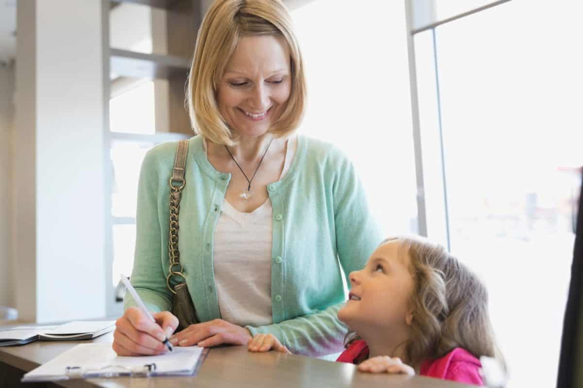 Mother and daughter filling out paperwork at counter