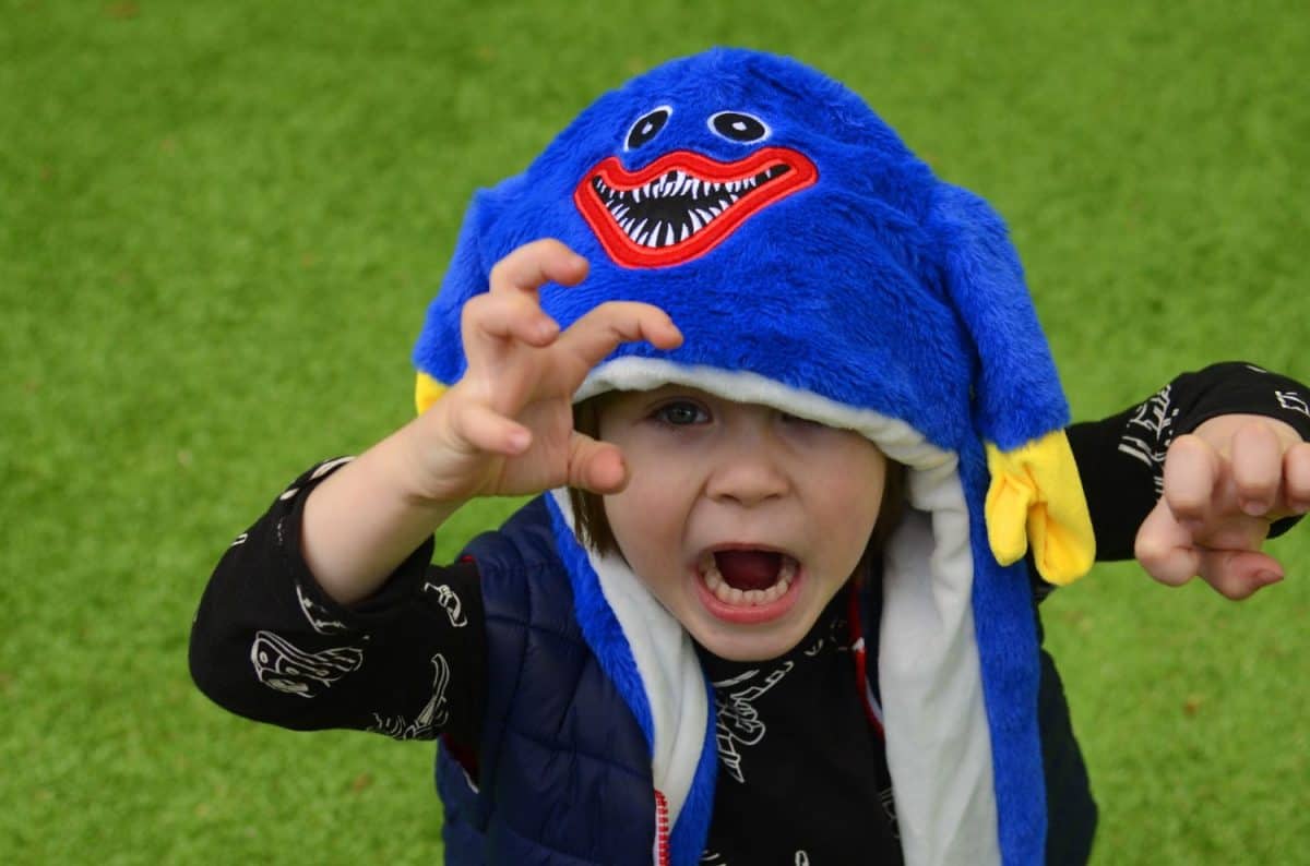 Purim, Halloween. Cute boy in a funny hat with ears. The smile of a child, a festive mood. A boy in a carnival costume. Portrait of a child in a festive headdress.