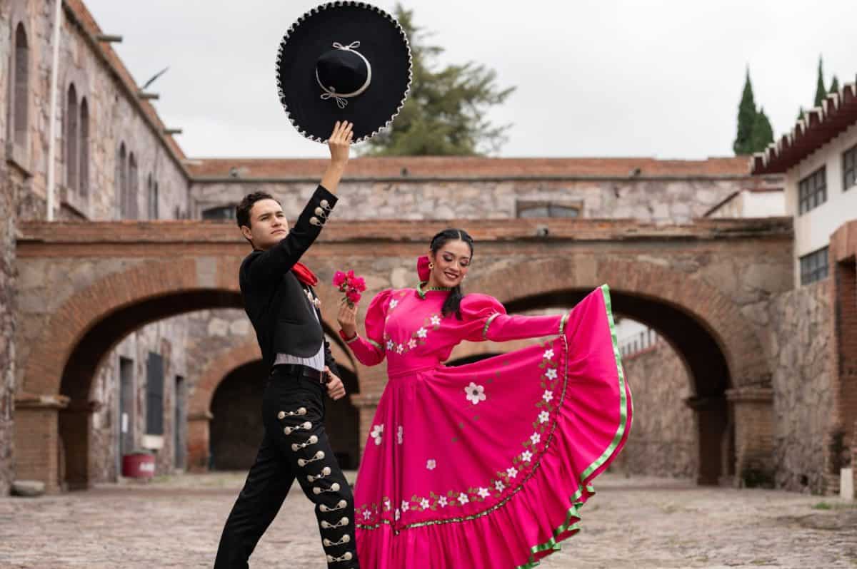 Latin couple of dancers wearing traditional Mexican dress from Guadalajara Jalisco Mexico Latin America, young hispanic woman and man in independence day or cinco de mayo parade or cultural Festival