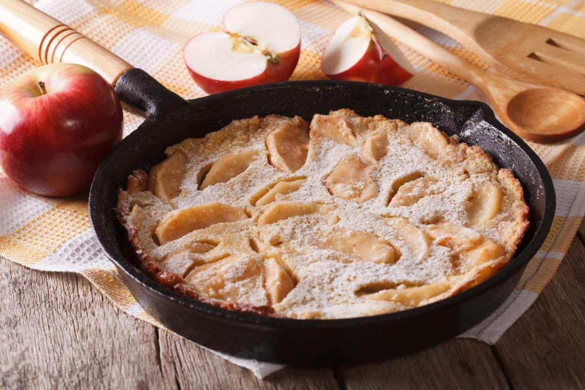 Dutch baby pancake with apples and cinnamon in a pan on a table close-up. Horizontal. Apple Dessert Recipes to Make the Most of This Fall's Harvest