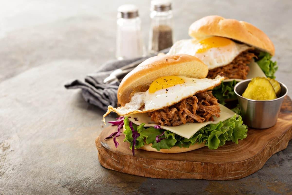 Pulled pork breakfast sandwiches with fried egg, cheese and lettuce