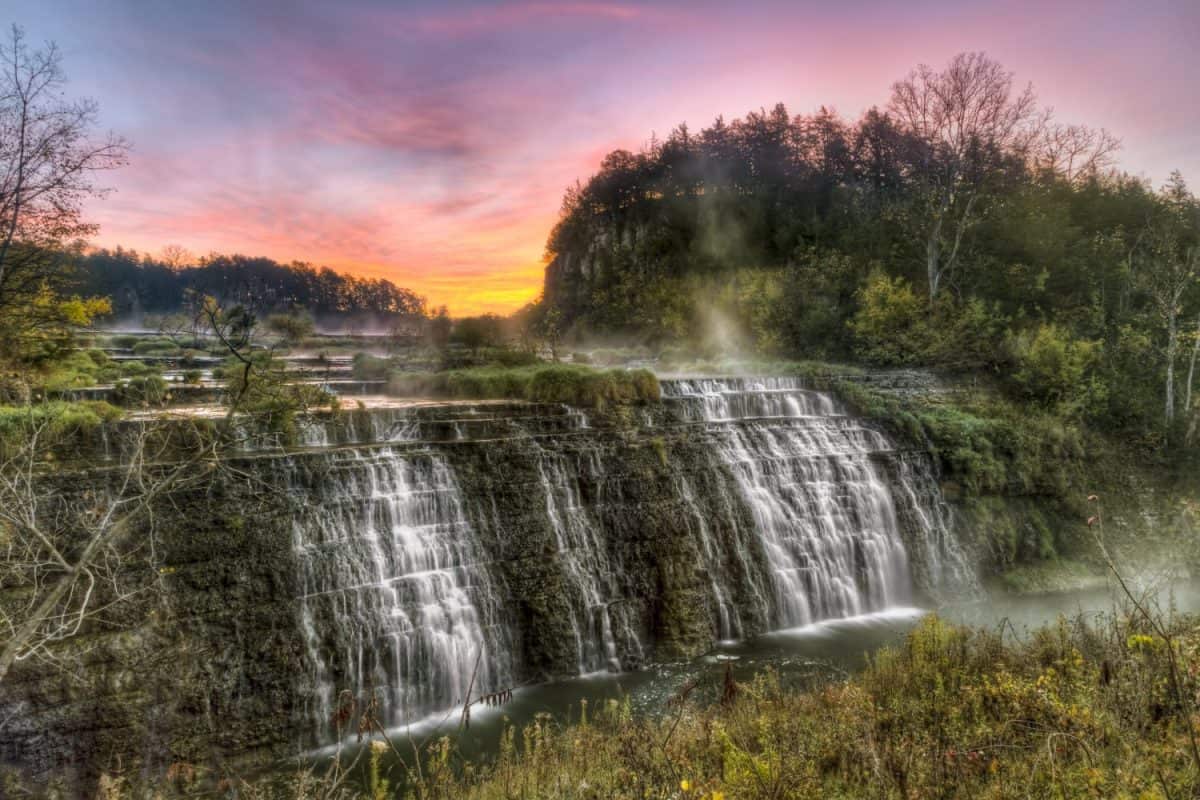 The sun rises behind Thunder Bay Falls near Galena, Illinois.