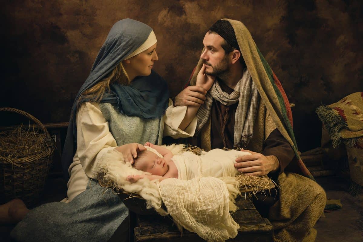 Couple reenacting a Christmas live nativity scene with their 8 days old little newborn baby