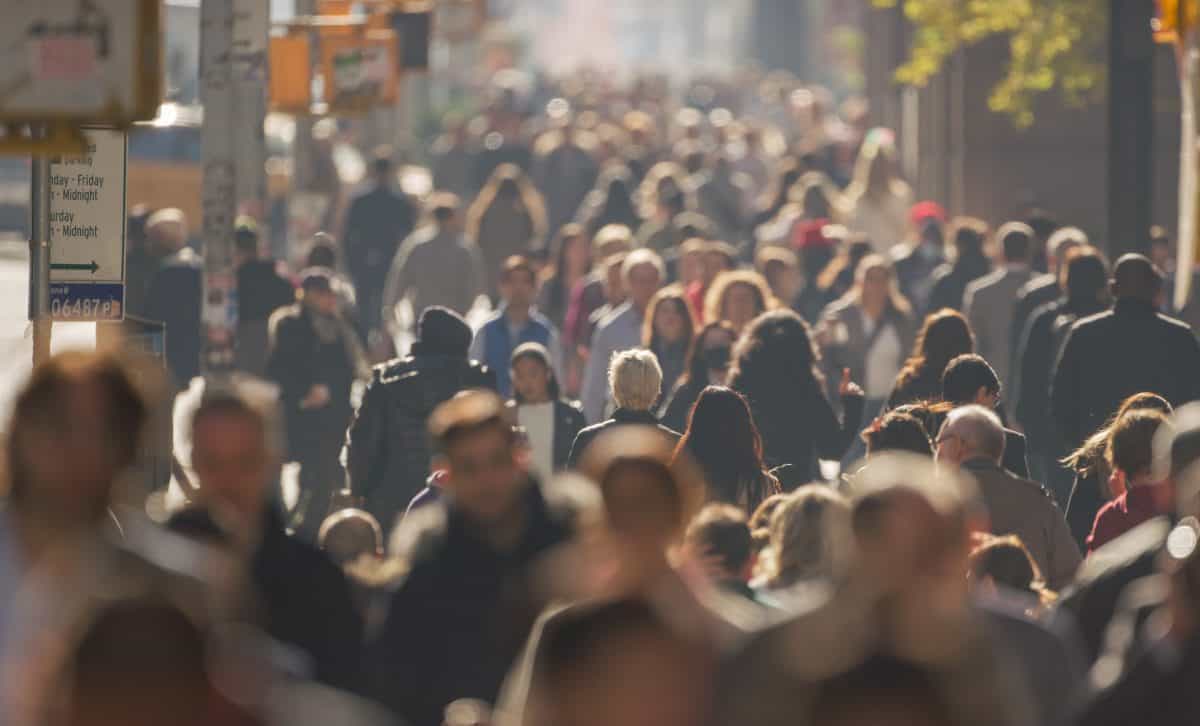 Crowd of people walking city street